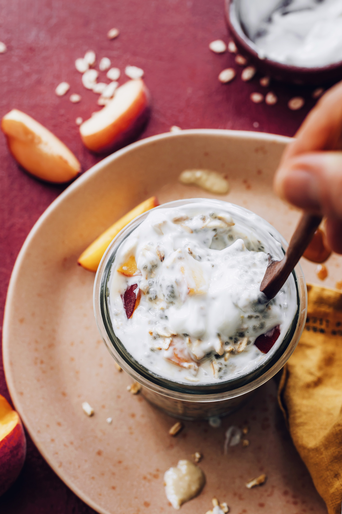 Stirring a jar of peaches and cream overnight oats