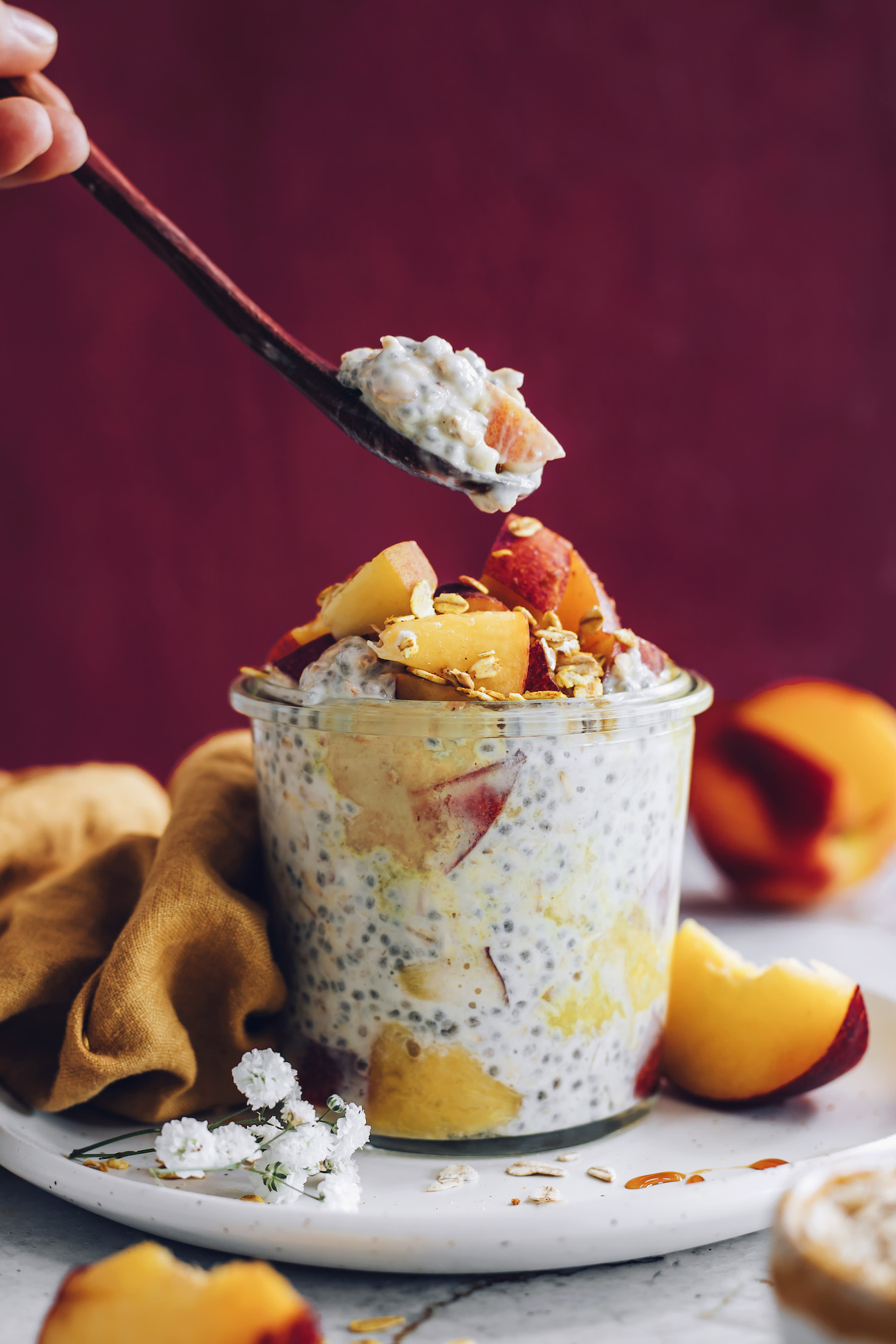 Picking up a bite of peaches and cream overnight oats from a jar