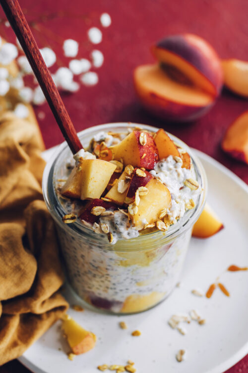 Spoon in a jar of peaches n cream overnight oats