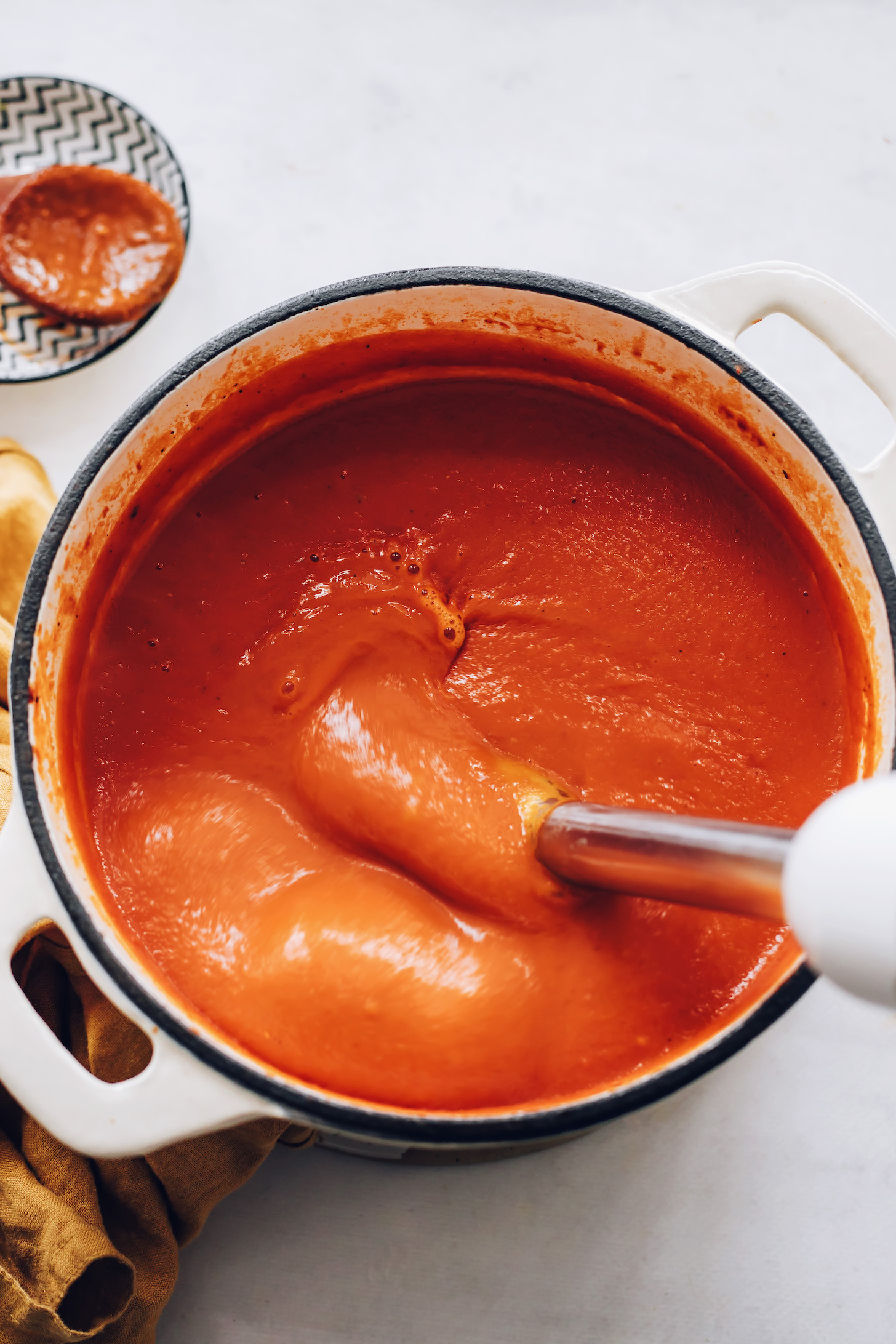 Using an immersion blender to make creamy tomato soup