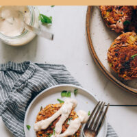 Plate of easy vegan and gluten-free crab cakes with vegan tartar sauce and fresh dill on top