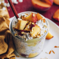 Jar of peaches n cream overnight oats topped with fresh peaches