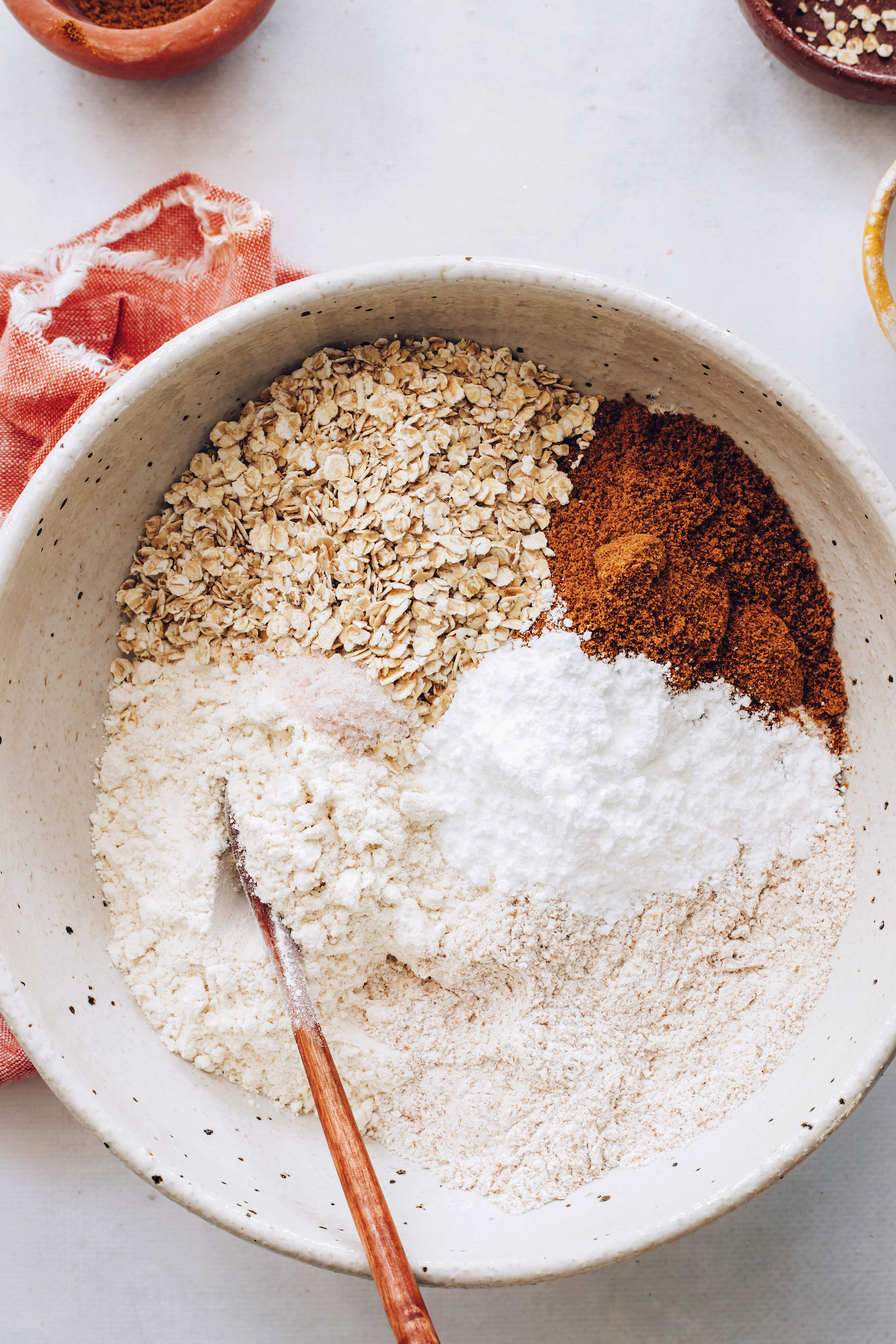 Spelt flour, whole wheat flour, rolled oats, coconut sugar, baking powder, and salt in a bowl