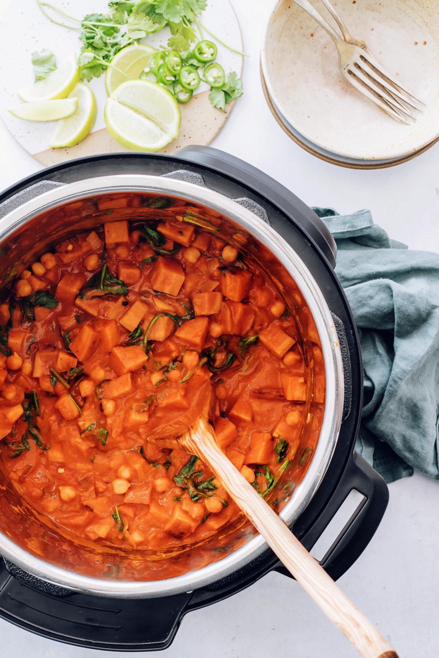 Wooden spoon in an Instant Pot of roasted red pepper chickpea curry