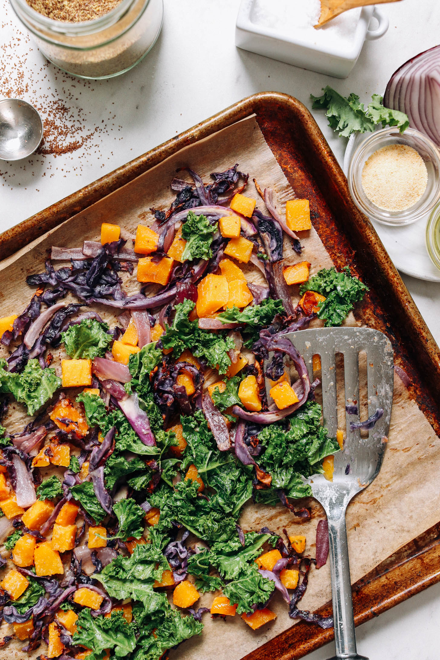 Baking sheet of roasted butternut squash, red onion, cabbage, and kale