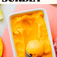 Ice cream scoop in a dish of mango sorbet
