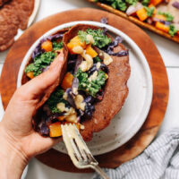 Adding miso sauce onto savory teff crepes with roasted vegetables
