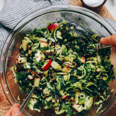 Tossing shaved brussel sprout salad with dressing