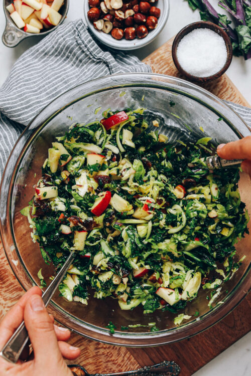 Tossing shaved brussel sprout salad with dressing