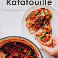 Pot of easy vegan 1-pot ratatouille with slices of ratatouille toasts on the side