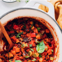 Pot of easy vegan 1-pot ratatouille with a spoon in it