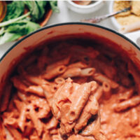 Pot of creamy vegan pink pasta with a spoon in it