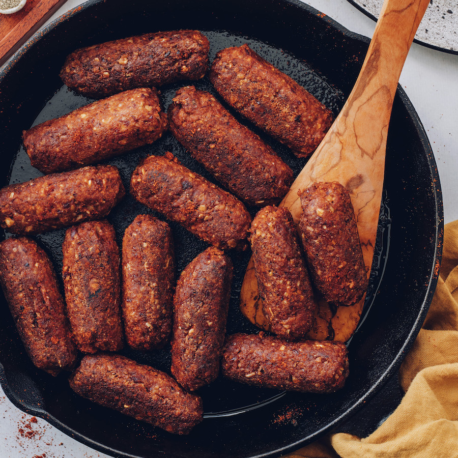 Cooking vegan chorizo sausage links in a skillet