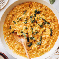 Pan of pumpkin risotto topped with crispy sage