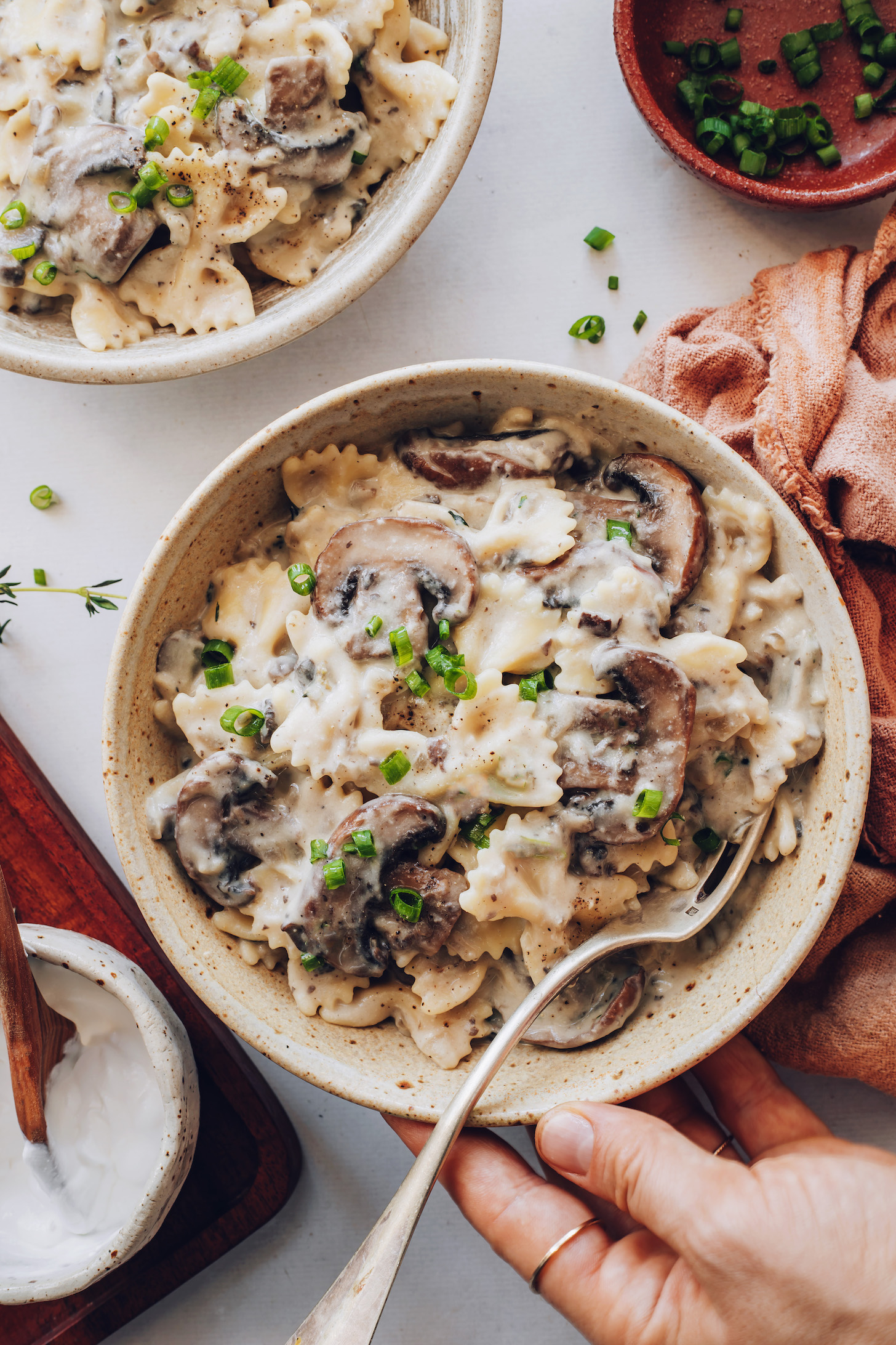 Bowls of vegan mushroom stroganoff topped with black pepper and chives