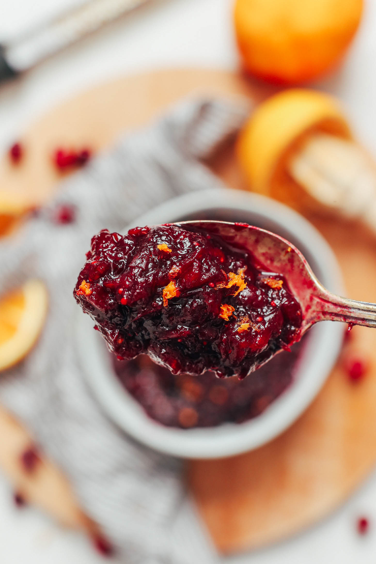 Close up shot of a spoonful of cranberry sauce topped with orange zest