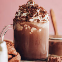Mug of instant hot chocolate topped with coconut whipped cream