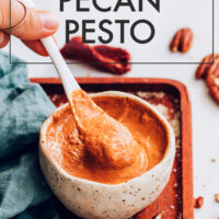 Jar of vegan and gluten-free chipotle pecan pesto with a spoon in it