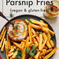 Plate of curry roasted parsnip fries with a dish of zesty dill yogurt sauce on the side