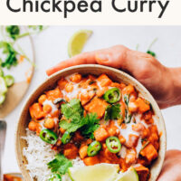 Hands holding a bowl of vegan and gluten-free instant pot-friendly roasted red pepper chickpea curry