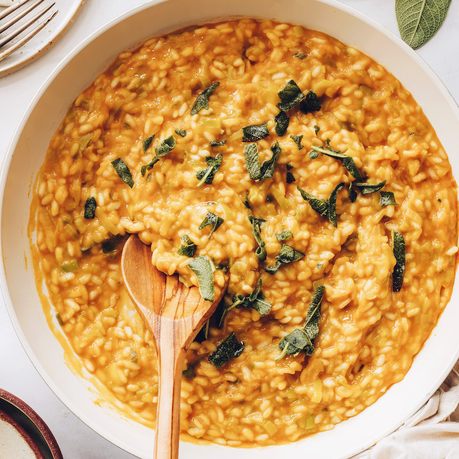 Pan of vegan pumpkin risotto topped with crispy sage