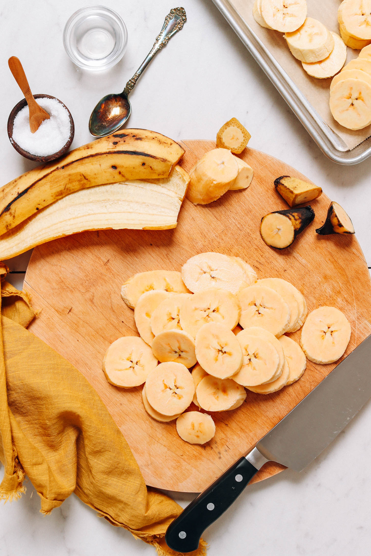 Plantain slices and peel on a cutting board