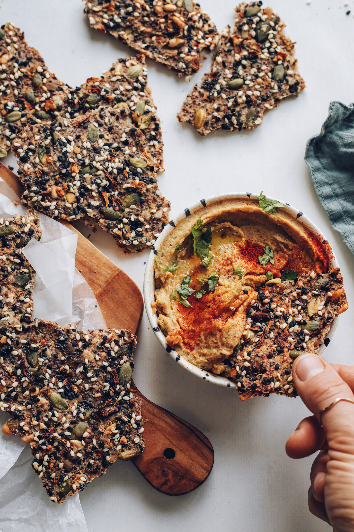 Dipping a seed cracker into hummus