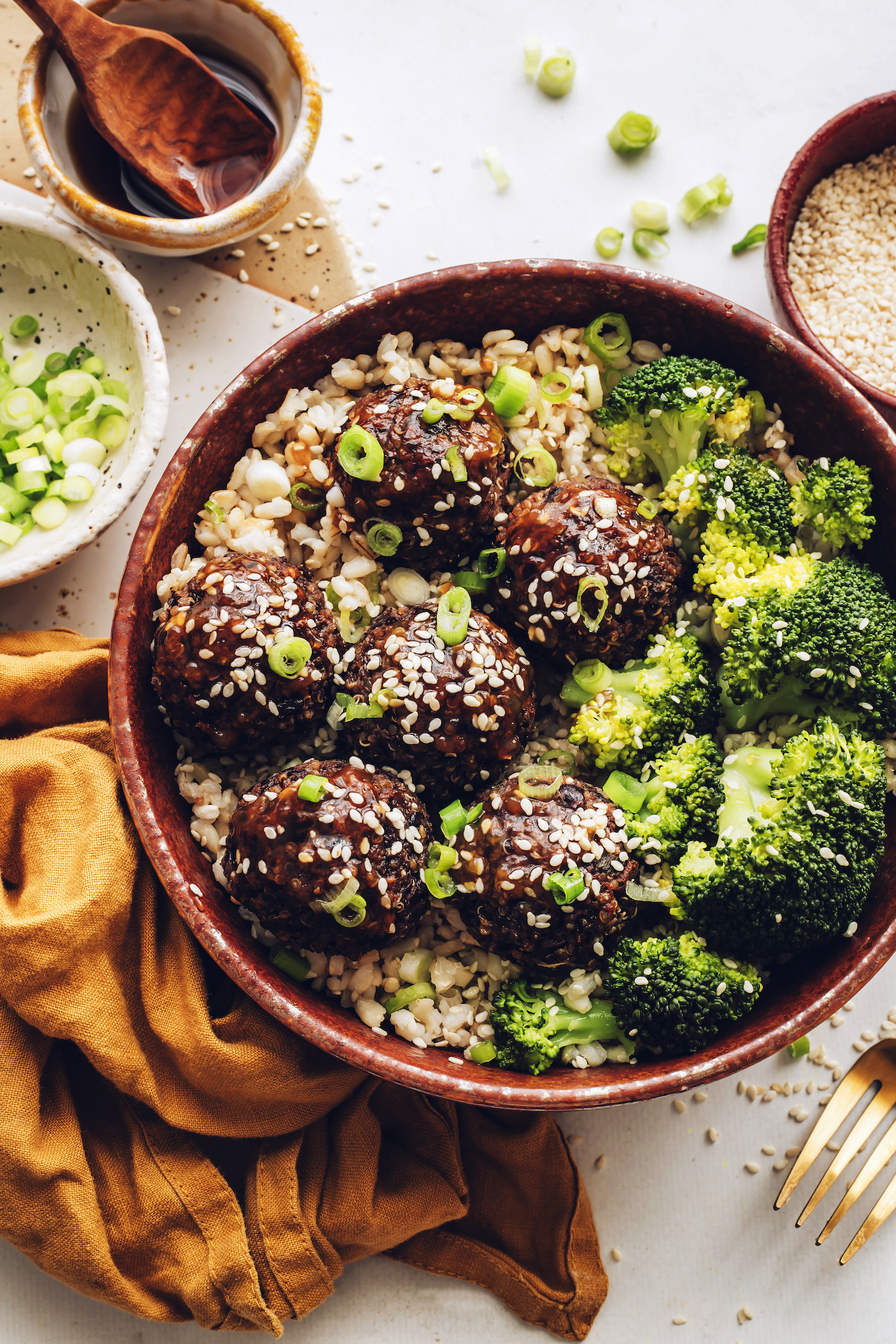 Top down shot of a bowl of sesame ginger vegan meatballs with broccoli over rice