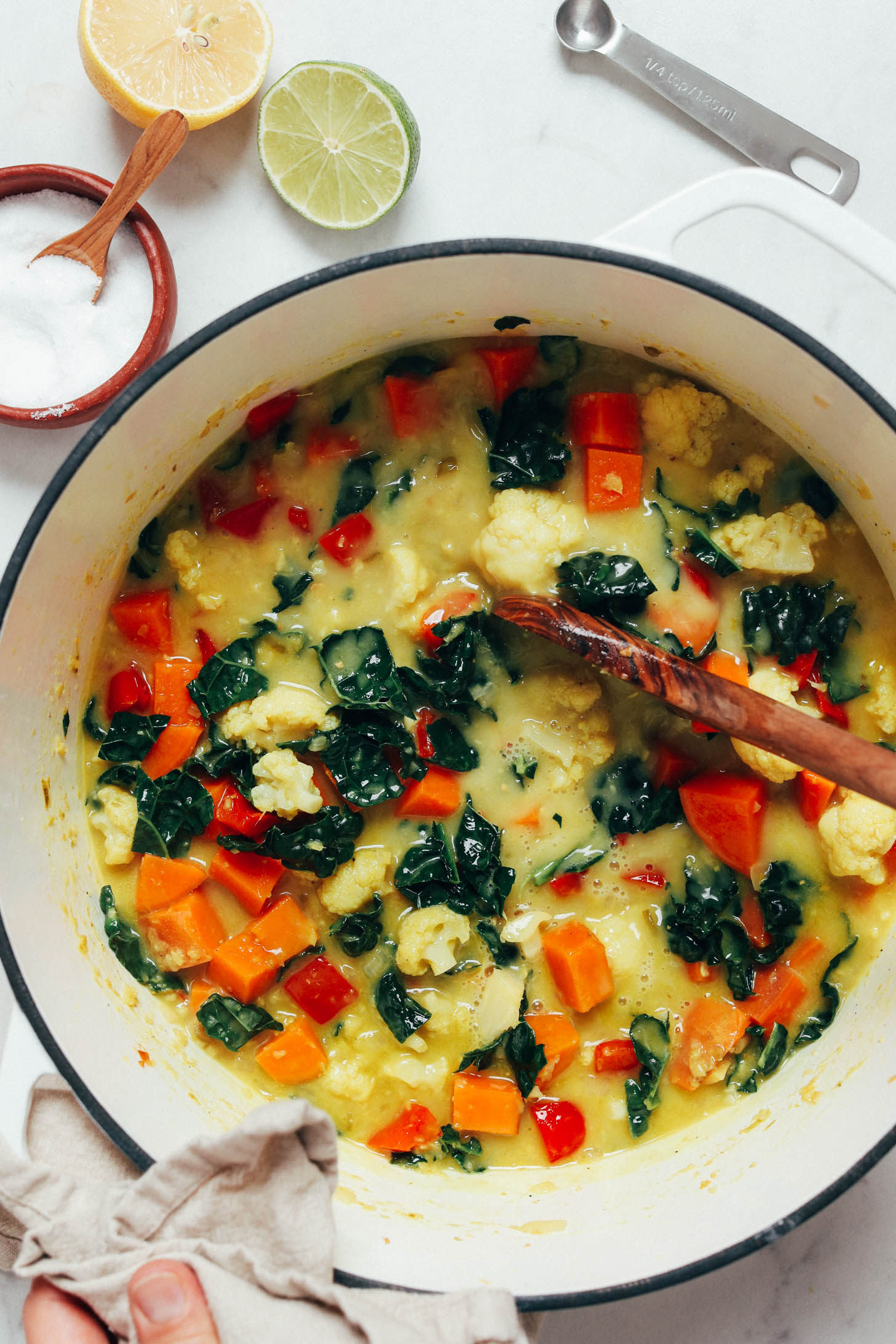 Stirring green curry with cauliflower, kale, and sweet potato