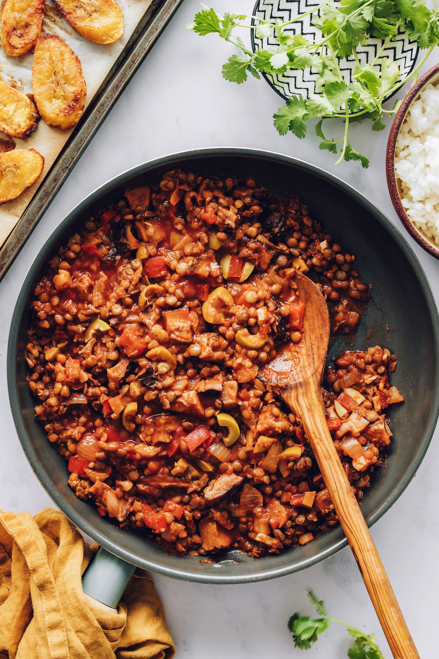 Wooden spoon in a skillet of lentil picadillo
