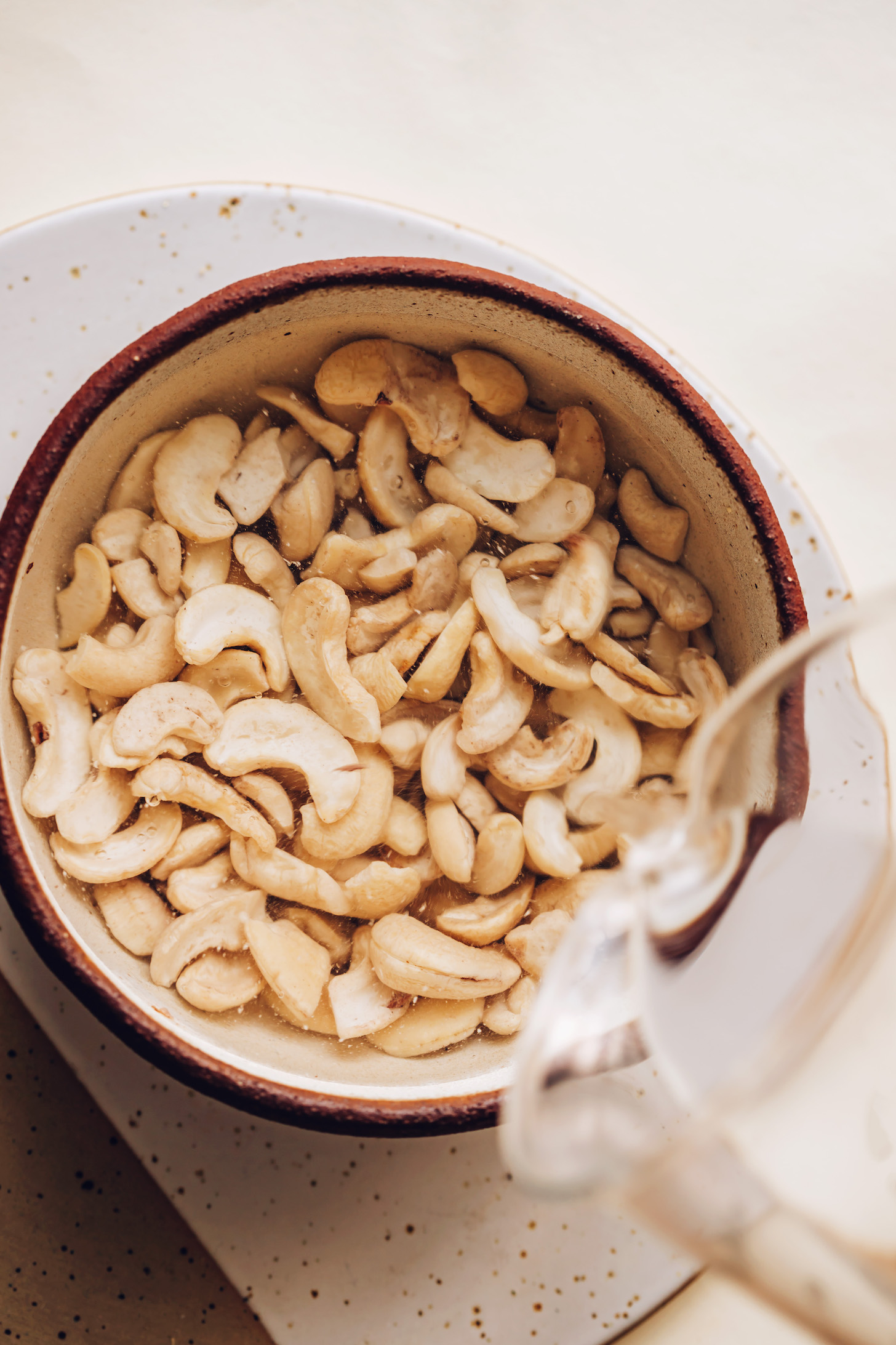 Pouring hot water over cashews to soak them