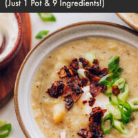 Bowl of creamy vegan potato soup topped with coconut bacon and green onion