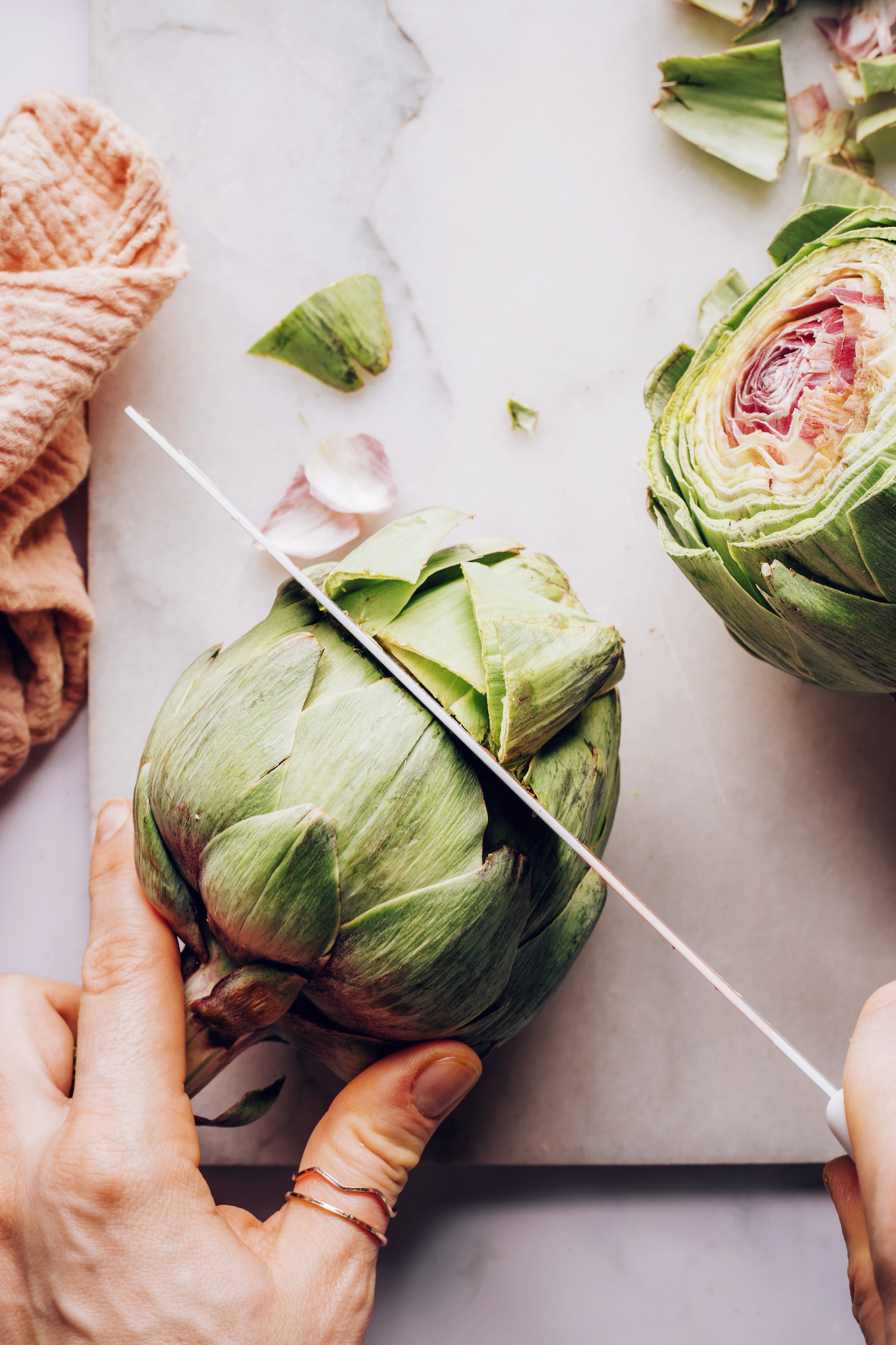 Showing how to prep an artichoke by slicing off the top