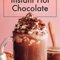 Cup of dairy-free instant hot chocolate with non-dairy whipped cream and cocoa powder on top