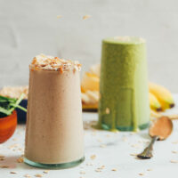 Two glasses of our peanut butter banana smoothie recipe with one having added spinach