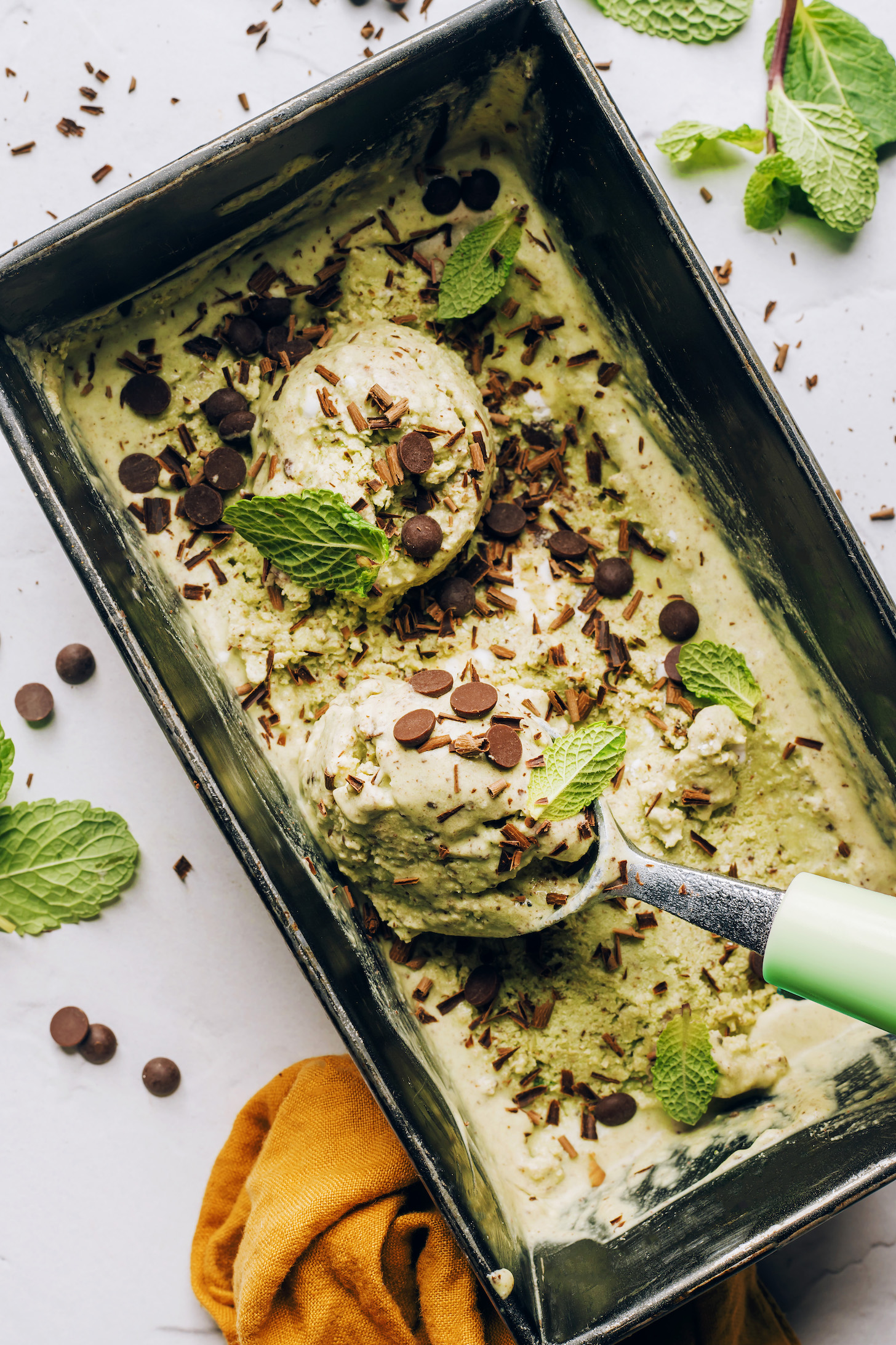 Vegan mint chocolate ice cream being scooped with an ice cream scoop 
