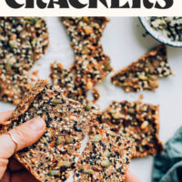 Breaking apart a cracker with text above it saying Easy Seed Crackers with Everything Bagel Seasoning