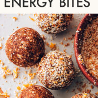 Vegan, gluten-free, no-bake orange cardamom energy bites being rolled in toasted coconut
