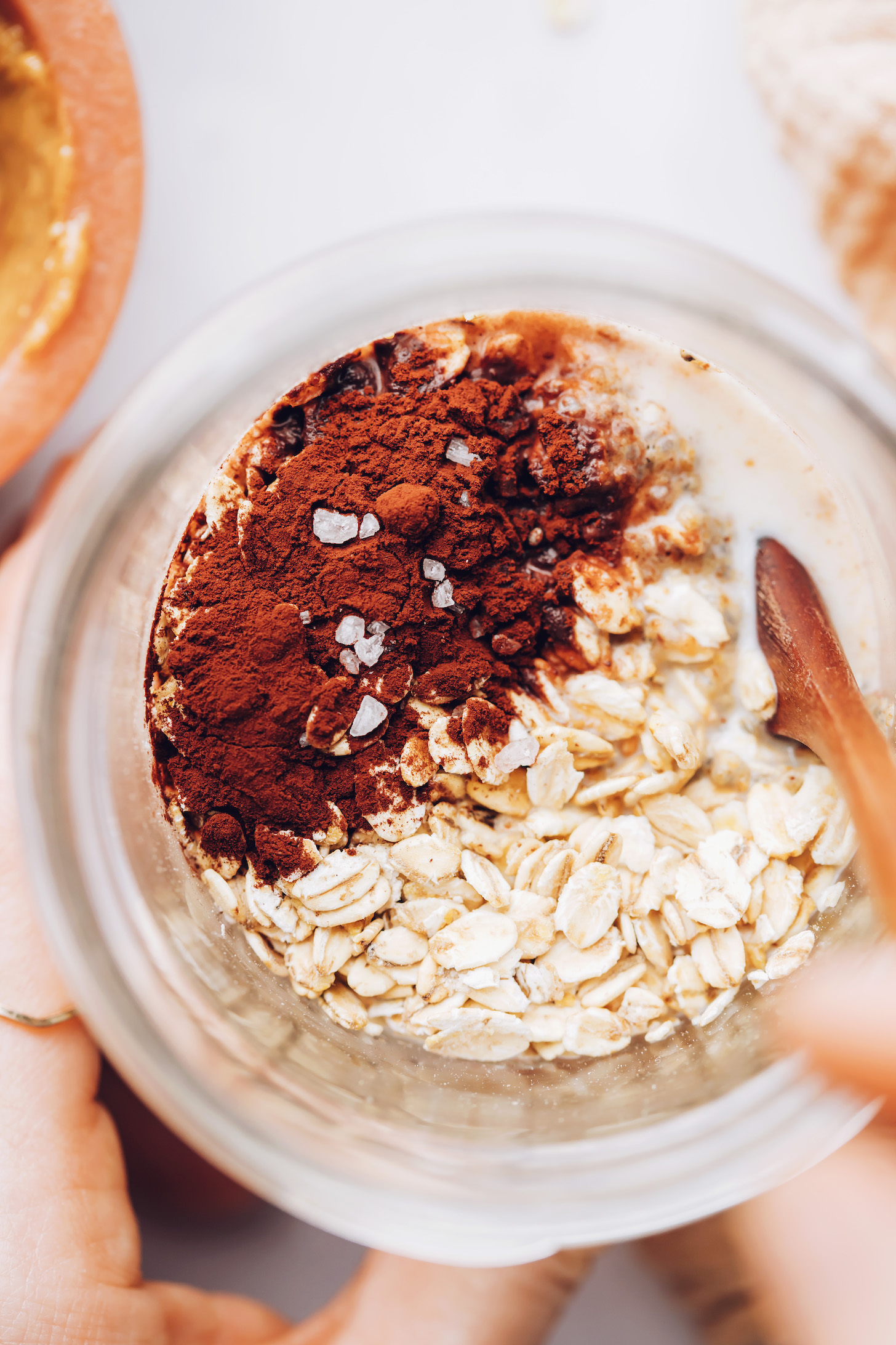 Rolled oats, cocoa powder, and almond milk in a jar