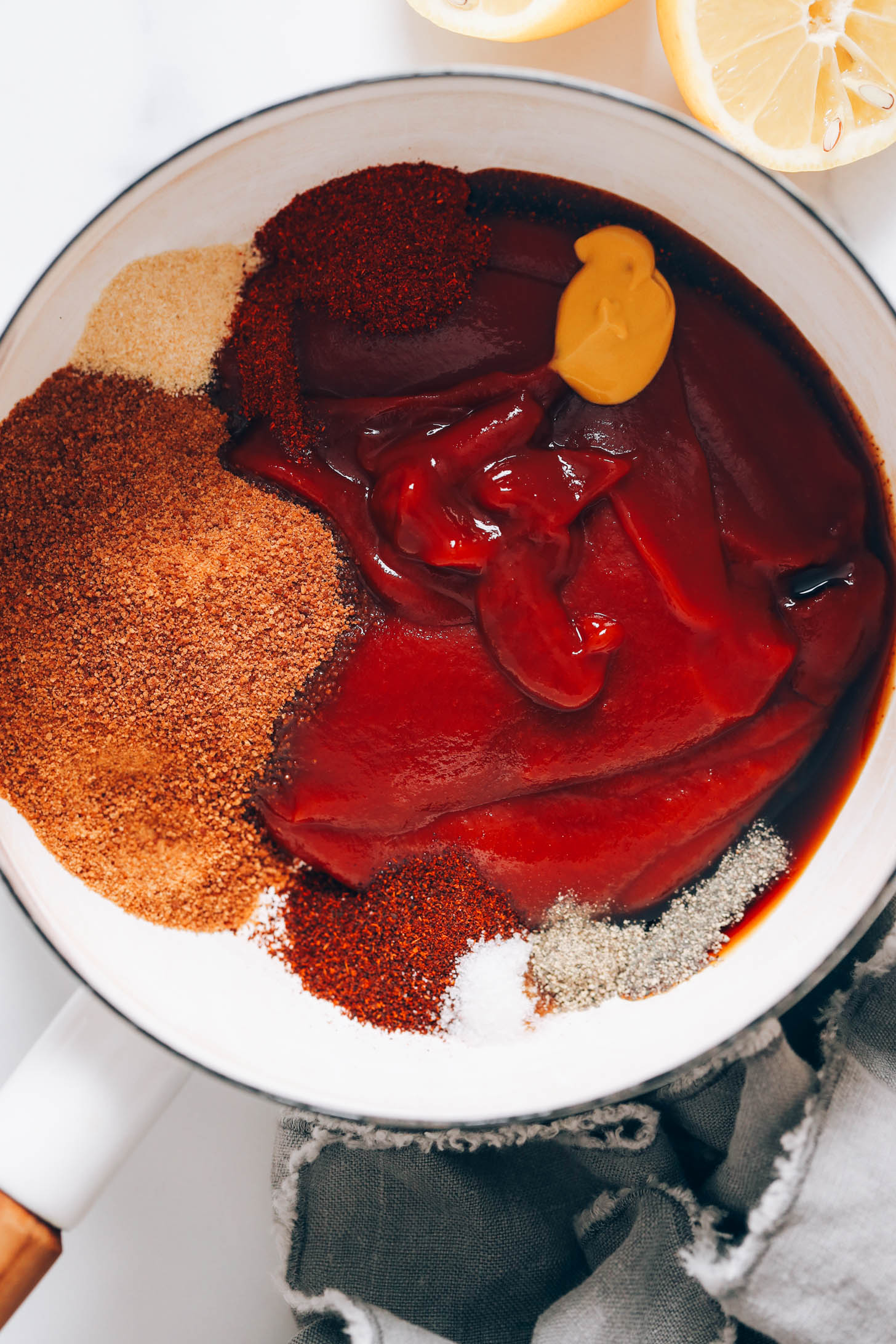 Large white saucepan with ketchup, spices, mustard, coconut sugar, tamari, salt, and vinegar