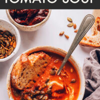 Bowl of creamy vegan and gluten-free 1-pot chipotle tomato soup with a piece of bread in it
