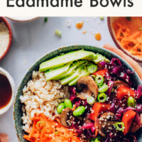 Hands holding a vegan and gluten-free rainbow edamame bowl with teriyaki sauce