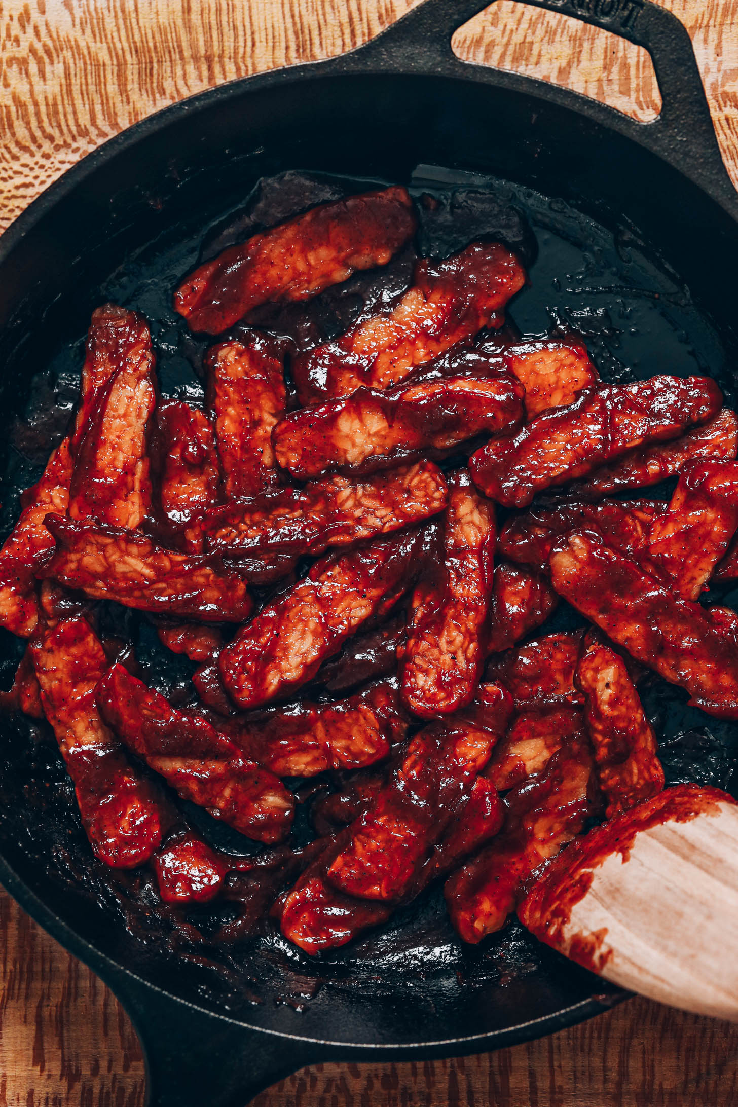 BBQ tempeh strips in a cast-iron skillet
