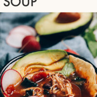 Bowl of easy chicken tortilla soup with avocado slices on top