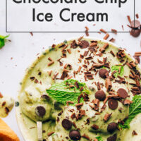 Bowl of vegan no-churn mint chocolate chip ice cream with mint leaves and chocolate chips on top