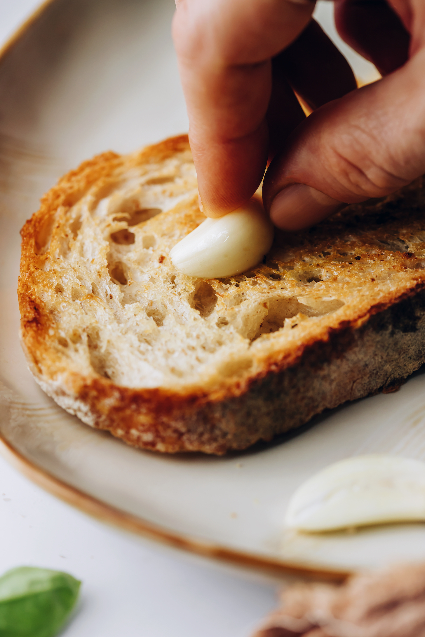Reiben Sie eine Knoblauchzehe auf eine Scheibe geröstetes Brot