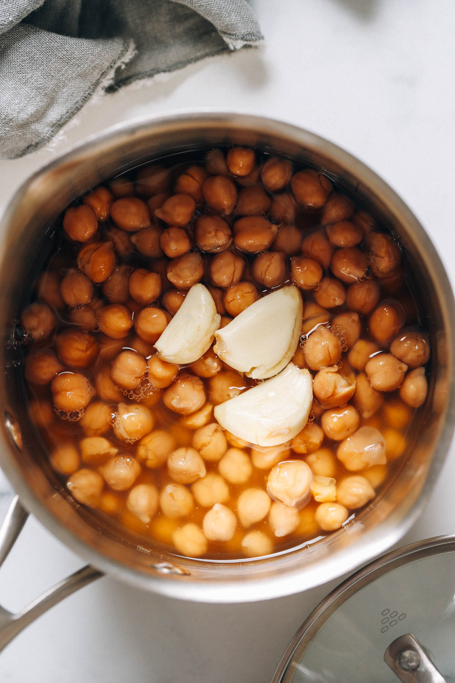 Chickpeas and garlic cloves in a saucepan