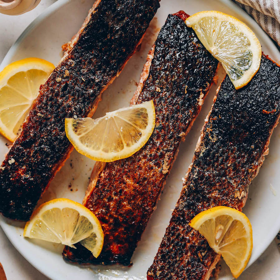 Plate of crispy skin salmon filets topped with lemon slices