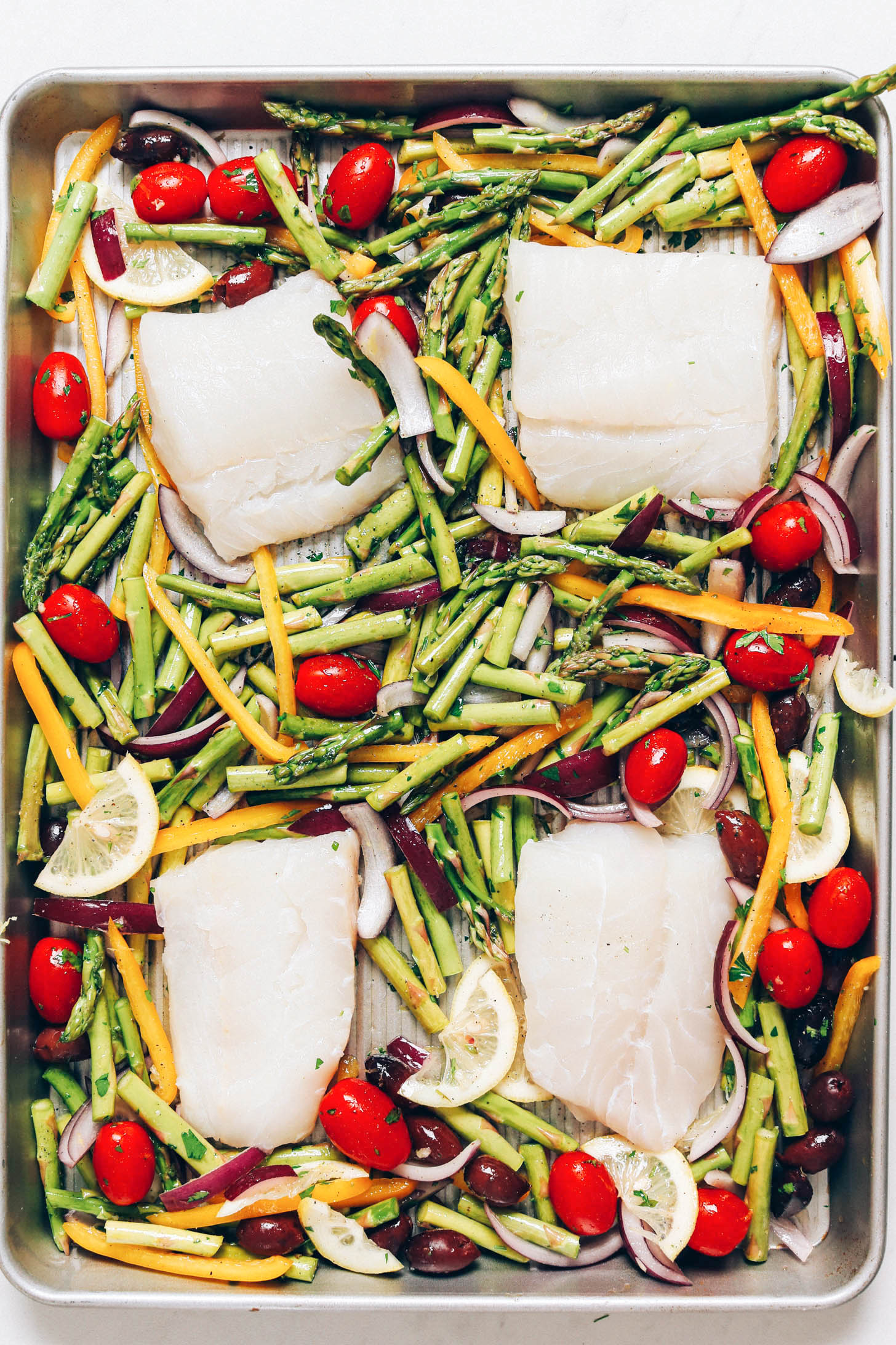 Sheet pan meal of baked cod fillets and vegetables