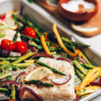 Baking sheet with baked cod and vegetables